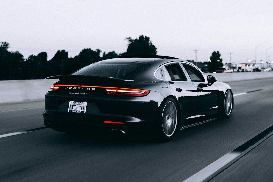 Dark sports car with gleaming bodywork on the road; illustrative photo